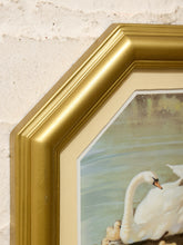 Load image into Gallery viewer, Close-up of an octagonal gold picture frame with a cream mat, showing a swan and duck scene, set against a textured off-white wall.
