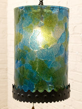 Load image into Gallery viewer, A cylindrical pendant lamp shade with a textured, marbled blue and green glass finish, featuring a black scalloped metal band at the bottom and a hanging chain.
