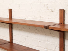 Load image into Gallery viewer, A close-up of a mid-century modern wooden floating shelf with dark metal brackets, mounted against a white painted brick wall.
