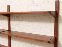 Load image into Gallery viewer, Mid-century modern wall-mounted wooden shelves with a warm medium-brown finish, shown against a white painted brick wall.
