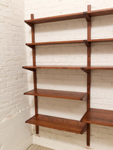 Load image into Gallery viewer, Mid-century modern wall-mounted wooden shelves in a warm brown finish, mounted on a white brick wall.
