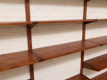 Load image into Gallery viewer, Wooden floating shelves mounted on a white painted brick wall, shown in a close-up view with multiple shelves visible.
