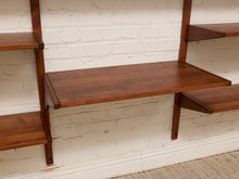Load image into Gallery viewer, Mid-century modern wall-mounted wooden shelves in a warm medium-brown finish, shown against a white brick wall.
