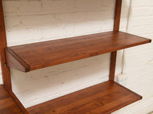 Load image into Gallery viewer, A two-tier wooden wall shelf with a warm medium-brown finish, mounted against a white painted brick wall.
