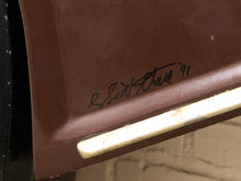 Load image into Gallery viewer, Close-up of a brown molded panel with a black handwritten signature reading 'R. Scott Thorne 91' and a cream-colored trim piece along the bottom edge.
