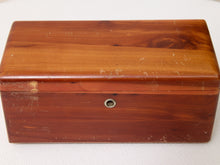 Load image into Gallery viewer, A rectangular wooden box with a glossy reddish-brown finish, showing visible wear, scratches, and scuffs on the surface. It has a small round metal lock or keyhole on the front and is photographed on a white textured fabric background.
