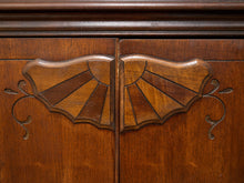 Load image into Gallery viewer, Close-up of a dark brown wooden cabinet door featuring an ornate inlaid geometric fan motif in matching wood tones and small scroll accents.
