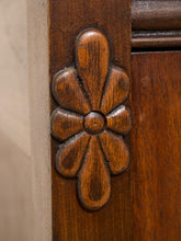 Load image into Gallery viewer, Close-up of a carved wooden door knob with a floral or acanthus leaf motif, mounted on a dark brown wood panel next to a light beige wall.
