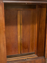 Load image into Gallery viewer, Close-up of the interior wooden cabinet or shelf with warm medium-brown wood panels and a vertical lighter wood accent strip.
