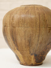 Load image into Gallery viewer, A close-up of a rustic ceramic vase with a rounded, bulbous shape and a textured glaze in earthy brown, tan, and gold tones.

