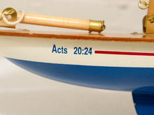 Load image into Gallery viewer, Close-up of a wooden model sailboat with a white hull, blue lower section, red stripe, and brass rigging. The text 'Acts 20:24' is printed in blue on the side.
