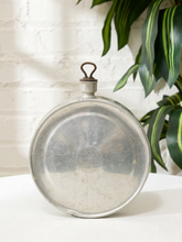 Load image into Gallery viewer, Antique round metal water flask with loop cap, embossed maker's mark, and aged patina
