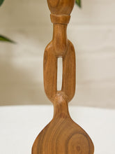 Load image into Gallery viewer, A close-up of a carved wooden decorative object with a smooth medium-brown finish and visible wood grain, set against a softly blurred light background.
