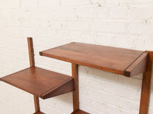 Load image into Gallery viewer, Mid-century modern wooden wall-mounted shelving unit with a warm medium-brown finish, shown against a white painted brick wall.
