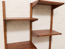 Load image into Gallery viewer, Mid-century modern wall-mounted wooden shelving unit with three tiers of open shelves in a warm walnut finish, set against a white painted brick wall.
