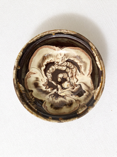 Load image into Gallery viewer, A round ceramic bowl viewed from directly above, featuring a marbled pattern of cream, beige, and dark brown glazes on a white textured background.
