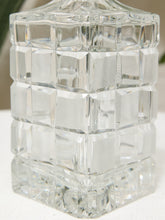 Load image into Gallery viewer, Clear glass decanter with a geometric, faceted cube pattern and a matching screw-top lid, shown on a light surface.
