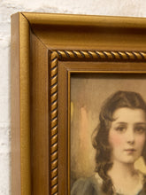 Load image into Gallery viewer, Close-up of a vintage-style framed portrait painting showing part of a woman's face, with a decorative gold-toned frame against a white textured wall.
