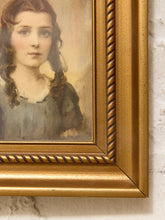 Load image into Gallery viewer, Close-up of a framed portrait painting showing part of a young woman with long brown hair and a blue dress, set in an ornate gold frame against a white textured wall.
