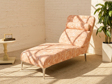 Load image into Gallery viewer, Vintage chaise lounge with peach and cream palm leaf upholstery, rounded back, and matching bolster cushion

