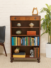 Load image into Gallery viewer, Antique tall wood bookshelf with four open shelves, upper drawer, round metal pulls, and turned front feet

