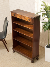 Load image into Gallery viewer, Antique tall wood bookshelf with four open shelves, upper drawer, round metal pulls, and turned front feet
