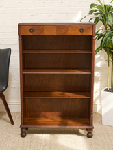 Load image into Gallery viewer, Antique tall wood bookshelf with four open shelves, upper drawer, round metal pulls, and turned front feet
