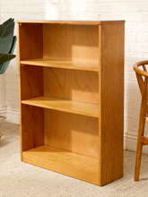 Load image into Gallery viewer, Vintage light wood bookcase with three open shelf levels, natural wood grain, and compact rectangular silhouette
