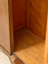 Load image into Gallery viewer, Close-up of the interior corner of a wooden cabinet or shelf, showing warm medium-brown wood grain on the walls and floor.
