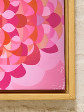 Load image into Gallery viewer, A close-up of a framed abstract floral canvas print featuring overlapping petal-like shapes in shades of pink, coral, orange, and magenta, set in a light natural wood frame against a textured off-white wall.
