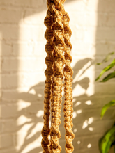 Load image into Gallery viewer, Vintage 1970s natural fiber macramé plant hanger with braided knots, twisted cord details, and tassel


