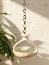 Load image into Gallery viewer, Vintage ceramic hanging bird feeder with cream glaze, orange-red speckles, open feeding area, and metal chain
