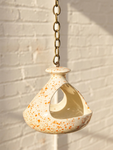 Load image into Gallery viewer, Vintage ceramic hanging bird feeder with cream glaze, orange-red speckles, open feeding area, and metal chain
