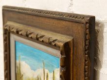 Load image into Gallery viewer, Vintage framed desert landscape painting with saguaro cacti, mountain backdrop, blue sky, and carved wood frame
