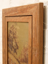 Load image into Gallery viewer, A close-up of a rustic medium-brown wooden picture frame with a double-molded border, holding a vintage landscape painting of birch trees, shown leaning against a white brick wall.
