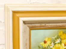 Load image into Gallery viewer, Close-up of a framed floral painting showing yellow flowers on a pale green background, with a distressed cream and mustard yellow frame.
