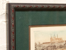 Load image into Gallery viewer, A close-up of a framed art print showing an antique architectural scene with a cathedral, featuring a dark brown ornate frame with red accents, a dark green mat, and a beige paper border.
