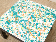 Load image into Gallery viewer, Vintage square side table with abstract green, orange, and yellow splatter-painted top and dark curved-leg base
