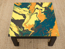 Load image into Gallery viewer, Vintage square side table with swirling yellow, orange, teal, and black marbled abstract top and dark curved-leg base
