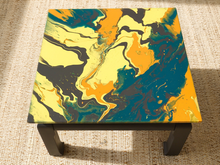 Load image into Gallery viewer, Vintage square side table with swirling yellow, orange, teal, and black marbled abstract top and dark curved-leg base
