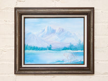 Load image into Gallery viewer, Vintage framed winter landscape painting with snowy mountain peaks, pale blue sky, bare branches, and dark wood frame
