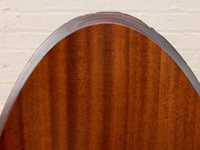 Load image into Gallery viewer, Close-up of a curved wooden surface with a rich reddish-brown wood grain and a dark metallic edge, set against a light off-white brick wall background.
