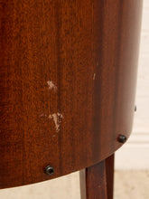 Load image into Gallery viewer, Close-up of the curved side panel of a dark reddish-brown wooden table or stool, showing wood grain, screws, and a few small white scratches on the finish.

