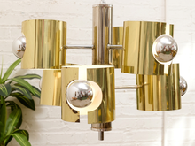 Load image into Gallery viewer, Vintage Space Age chandelier with polished brass cylindrical shades, mirrored chrome spheres, multiple lights, and chain suspension
