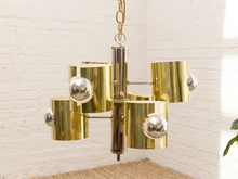 Load image into Gallery viewer, Vintage Space Age chandelier with polished brass cylindrical shades, mirrored chrome spheres, multiple lights, and chain suspension
