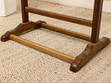 Load image into Gallery viewer, Close-up of a rustic wooden table base or stand with dark brown and medium brown stained wood legs and crossbars, resting on a beige woven jute rug.
