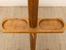Load image into Gallery viewer, Close-up of a wooden stand or rack with a horizontal bar featuring two oval recessed trays and a vertical post, shown on a textured beige rug.
