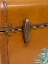 Load image into Gallery viewer, Close-up of a vintage orange-brown wooden trunk or suitcase with a brass latch and decorative painted floral detail in the lower right corner.
