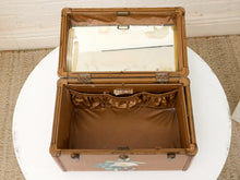 Load image into Gallery viewer, An open vintage brown suitcase with a mirror in the lid and a striped fabric lining, displayed on a round white table.
