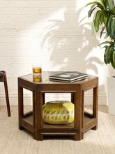 Load image into Gallery viewer, Vintage hexagonal wood side table with inset glass top, geometric framed sides, warm wood finish, and open lower shelf
